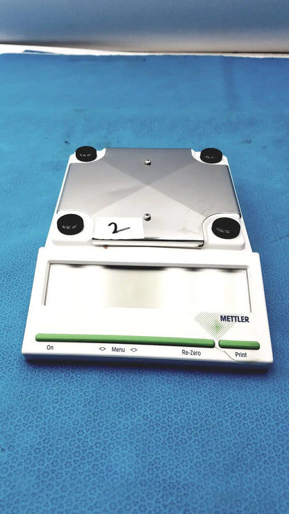 Silver and white mettler bb1200 digital scale with black rubber feet and branded front panel for precise measurements