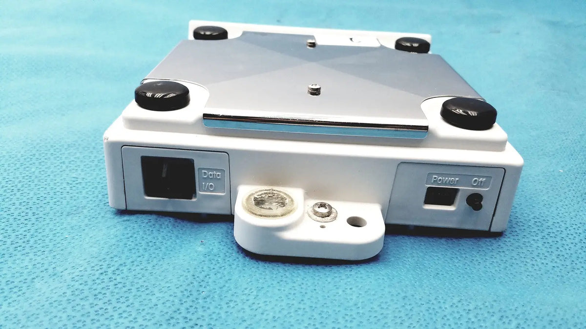 White and silver mettler bb1200 digital scale with black knobs labeled data i/o and power off featuring a coin on base