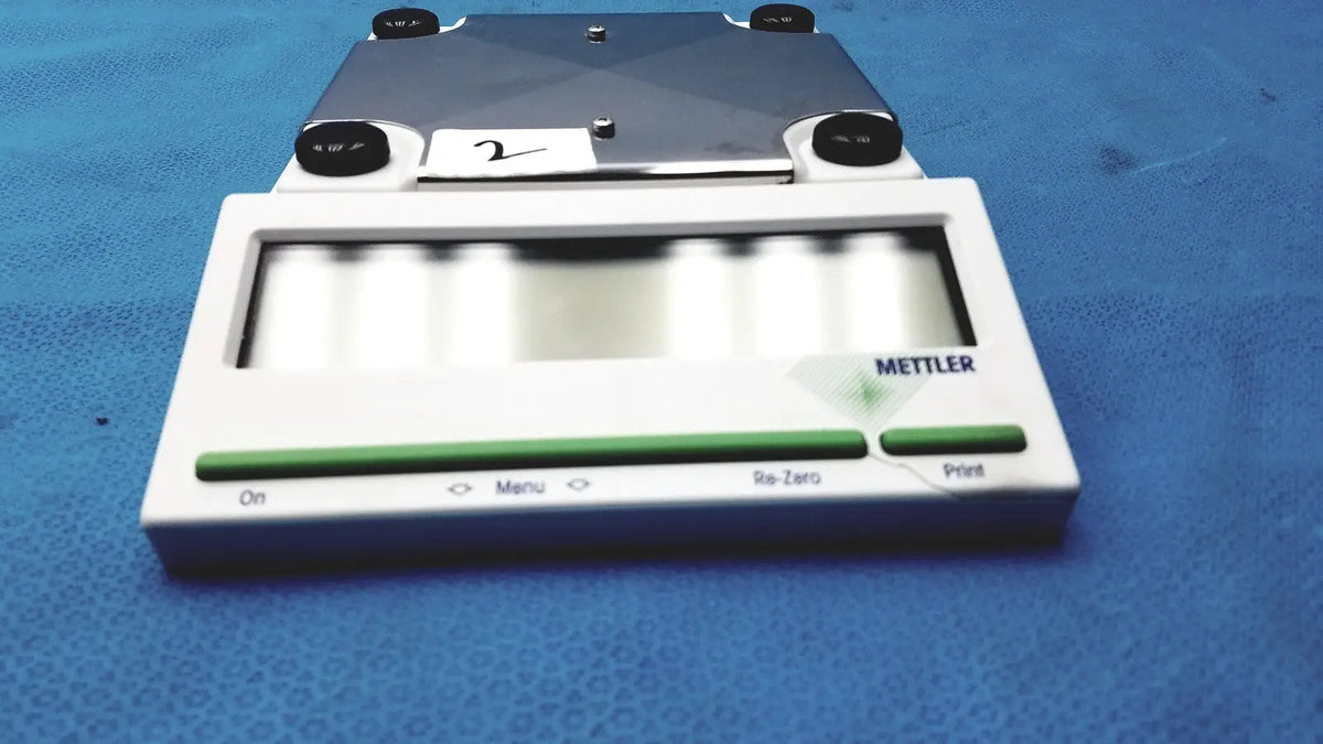 White and green mettler bb1200 digital scale with metallic weighing platform for precise measurements
