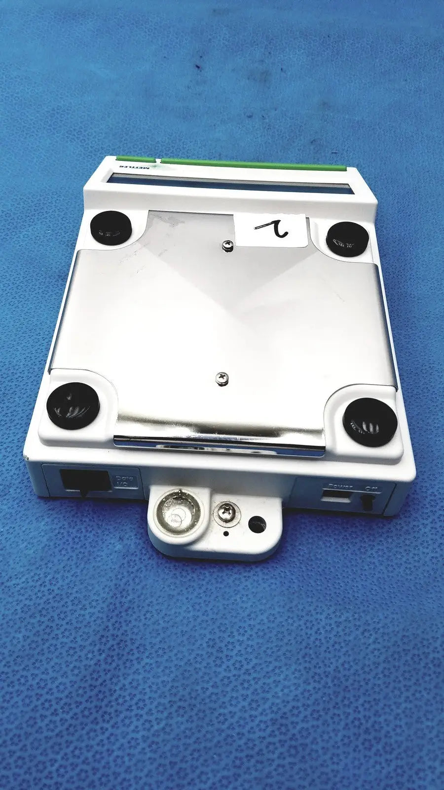 White rectangular mettler bb1200 digital scale with black circular ports and green stripe along the top edge