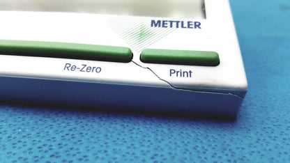 White and green mettler bb1200 digital scale with a visible crack along its side for precise electronic weighing