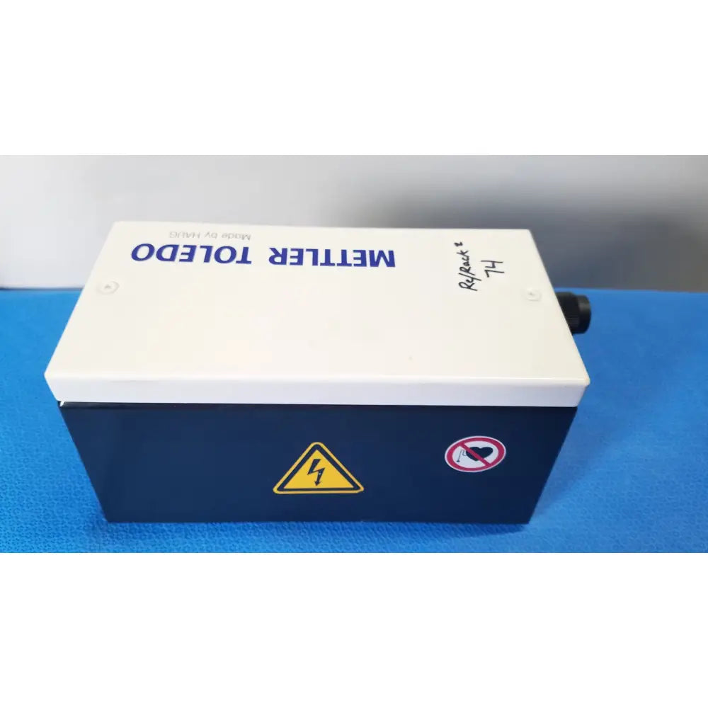 White and navy blue mettler toledo haug slc power supply box with yellow warning symbol and no heart sticker on side