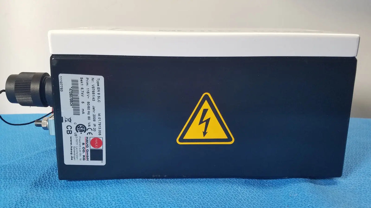 Black rectangular mettler toledo haug slc power supply with white top and yellow lightning bolt warning symbol from hannover
