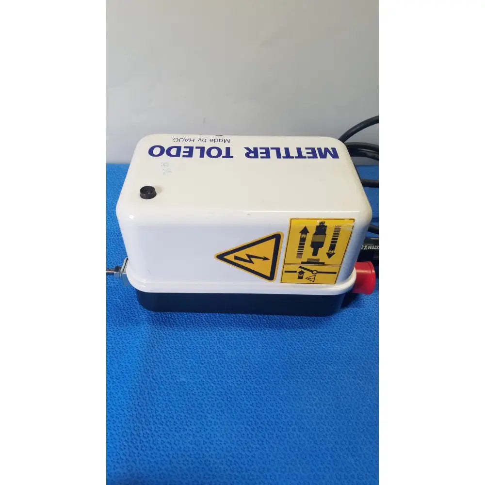 White and black mettler toledo electronic pump with red valve and safety labels for haug static eliminator power supply