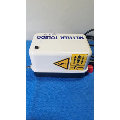 White and black mettler toledo electronic pump with red valve and safety labels for haug static eliminator power supply