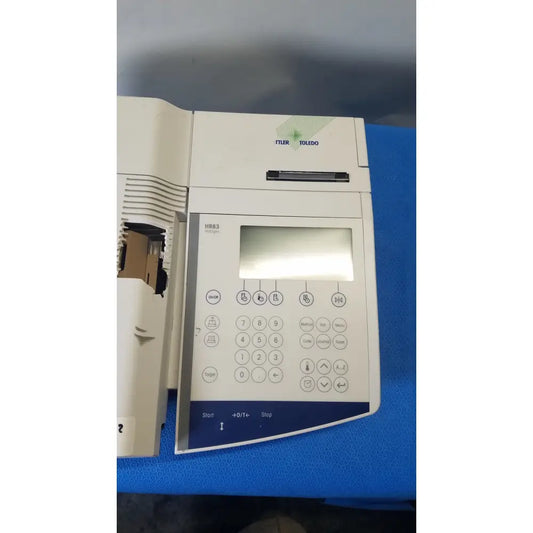 White plastic mettler toledo hr83-p halogen moisture analyzer with digital display and multiple function buttons