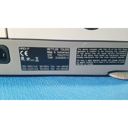 Silver metallic label with black text showing mettler toledo hr83-p halogen moisture analyzer made in switzerland