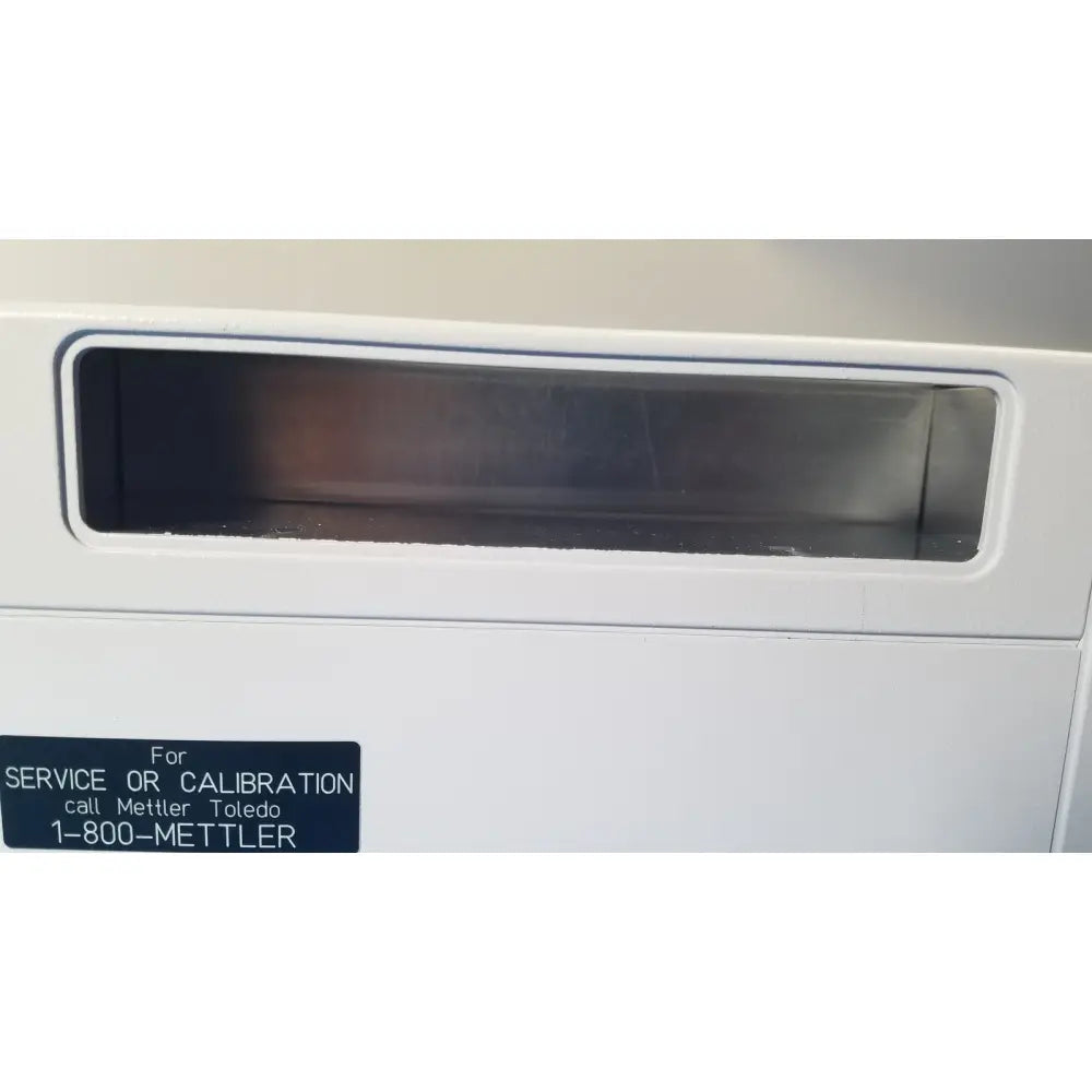 White plastic mettler toledo umx2 calibration service slot with dark rectangular opening on ultra-microbalance scale back side
