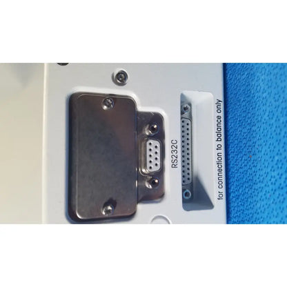 White plastic panel on the back of mettler toledo umx2 ultra-microbalance scale featuring metallic rs232c serial port and d-sub connector secured with screws
