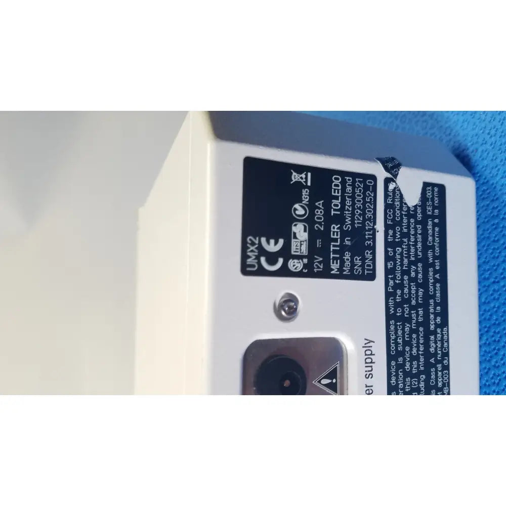 White rectangular mettler toledo 12v power supply unit with black label and silver screw for mettler toledo umx2 scale