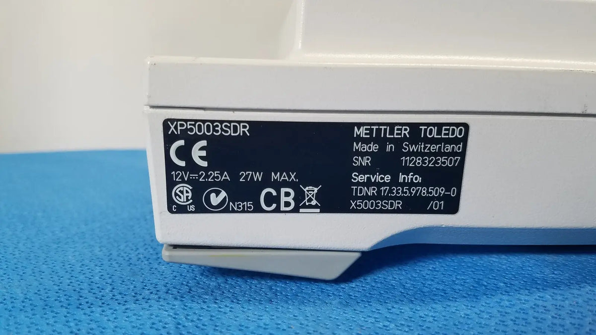 White mettler toledo xp5003sdr analytical balance with black label showing technical specs for toledo xp5003sdr communications module