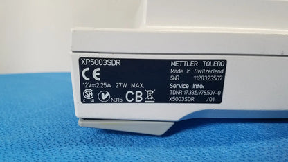 White mettler toledo xp5003sdr analytical balance with black label showing technical specs for toledo xp5003sdr communications module