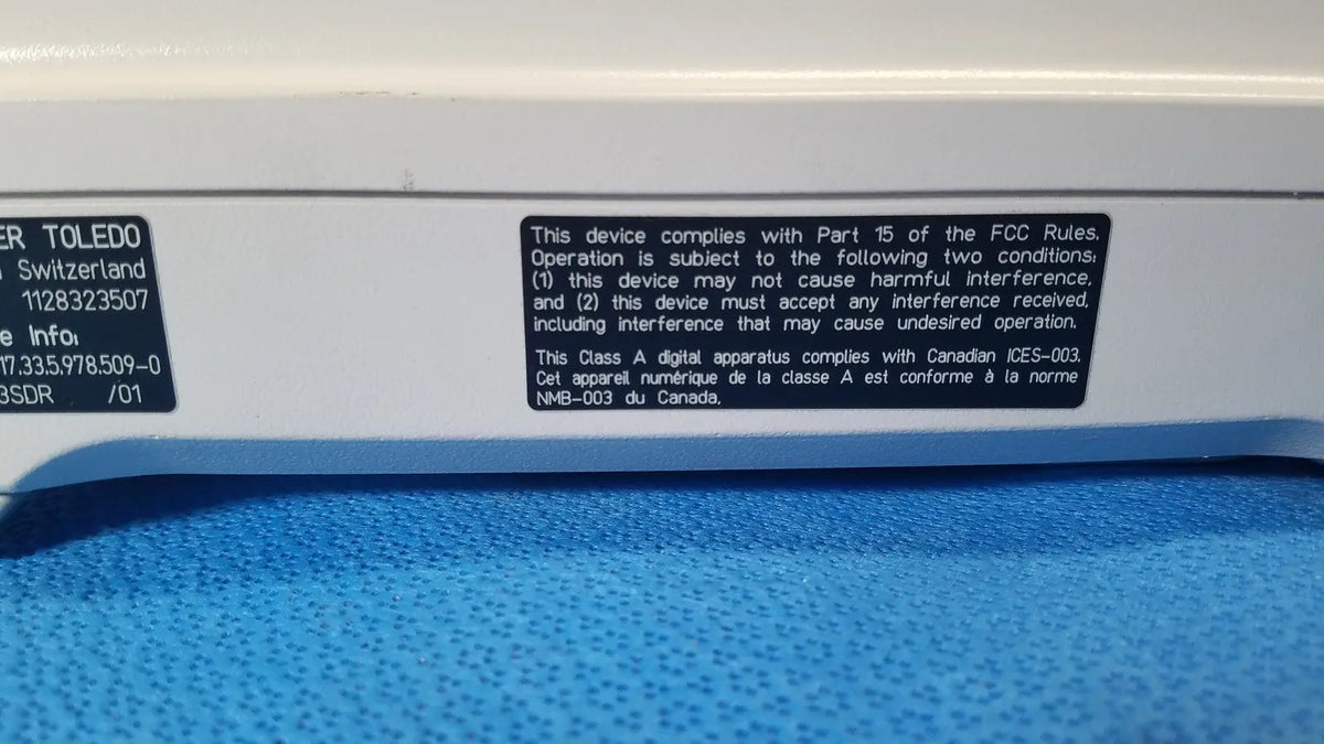 White plastic mettler toledo xp5003sdr communications module with black label showing model number 1128323507 on back side