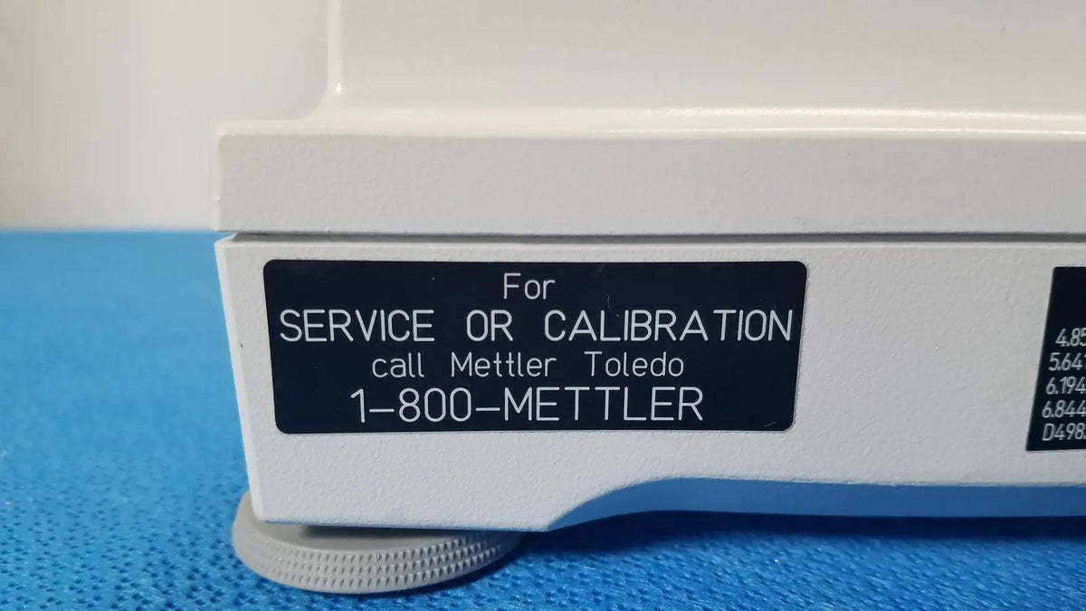 White laboratory balance with black label for service or calibration call mettler toledo 1-800-mettler with silver knobs for xp5003sdr