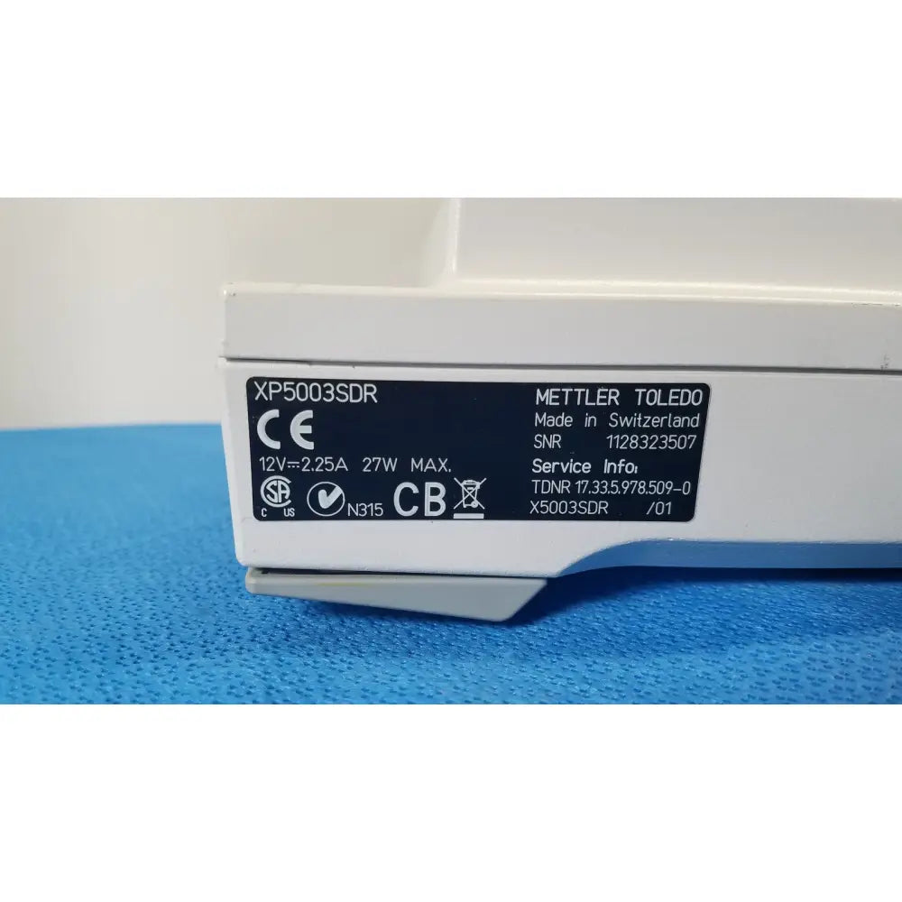White mettler toledo xp5003sdr analytical balance with black label showing technical specs for toledo xp5003sdr communications module