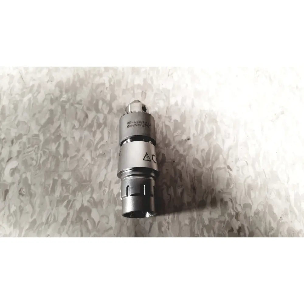 Silver metallic medical device cap with engraved markings and triangular warning symbol for microaire surgical instruments