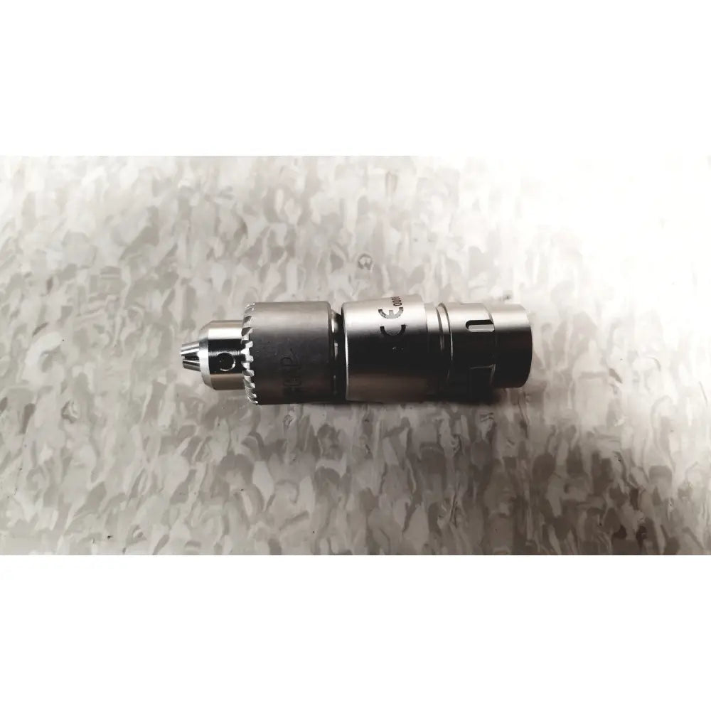 Silver metallic drill chuck with textured grip and engraved markings for microaire surgical instruments case