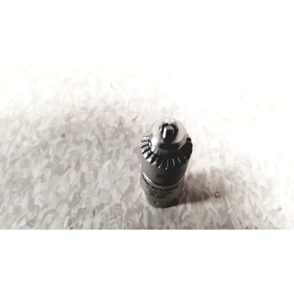 Black and silver microscrew drill chuck with gear-like exterior for microaire surgical instruments driver motor sag saw case