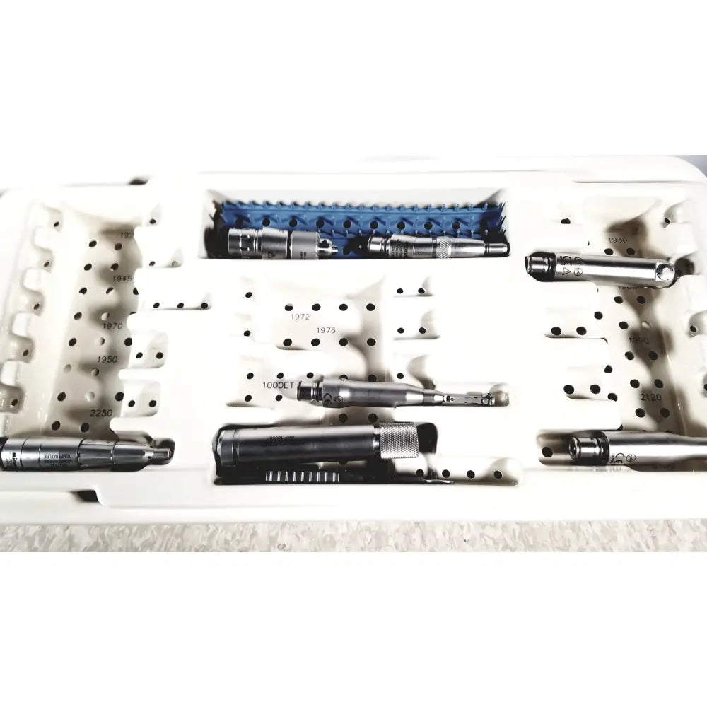 MicroAire surgical instruments driver motor and sag saw kit with metallic tools and blue plastic parts in white tray
