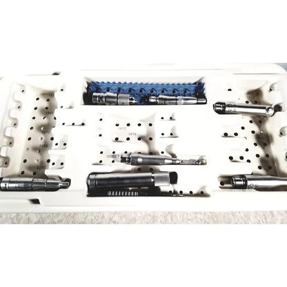 MicroAire surgical instruments driver motor and sag saw kit with metallic tools and blue plastic parts in white tray