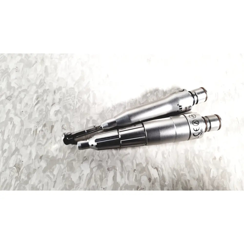Two silver metallic dental handpieces with black accents and engraved markings from microaire surgical instruments set