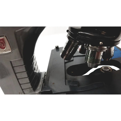Black metal microscope american optical spencer with silver-toned objective lenses and red logo plaque on the side