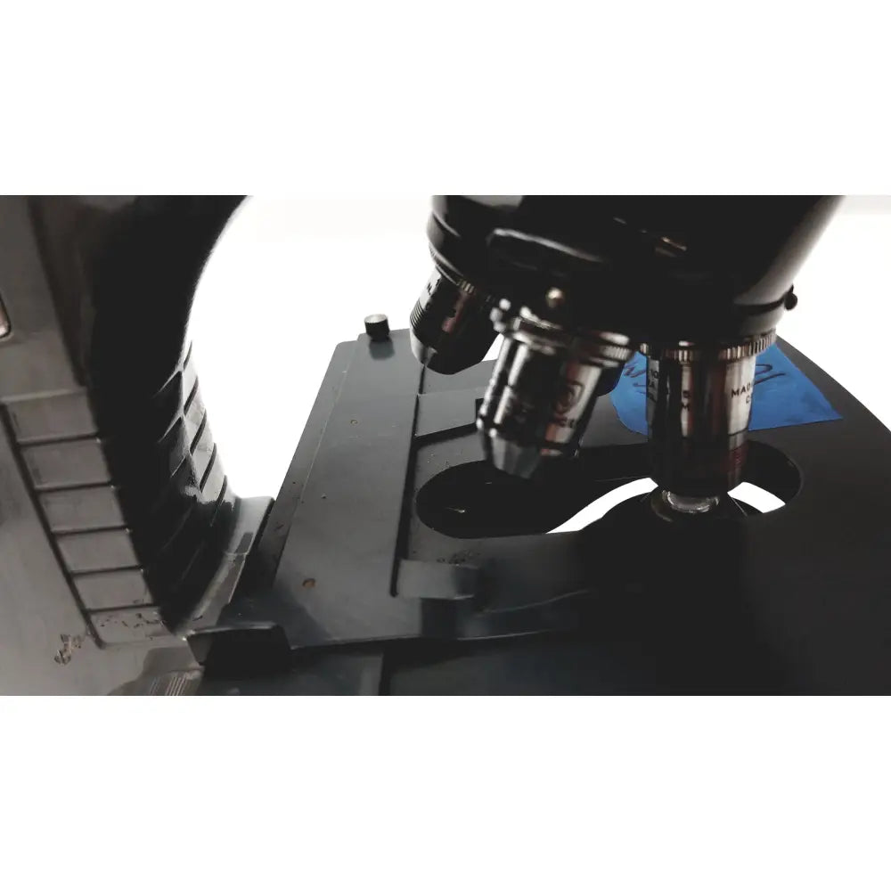 Microscope american optical spencer black metal with silver-tipped objective lenses and blue label on the stage