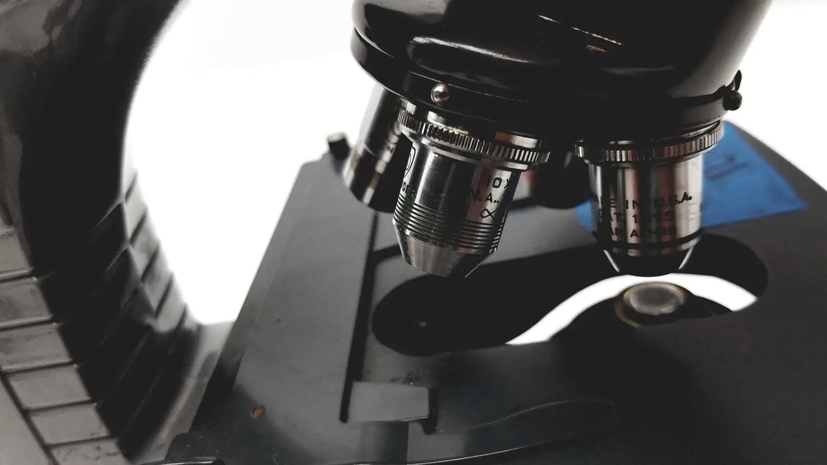 Black microscope american optical spencer with metallic objective lenses and engraved markings for precision use
