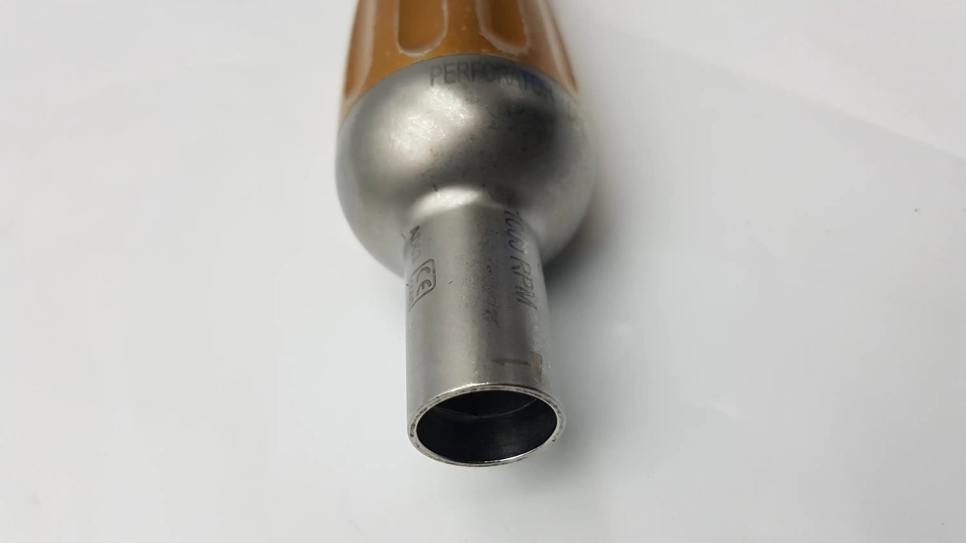 Close-up of the orange-handled stainless steel heat gun nozzle on the midas rex legend 1000 rpm ad03 perforator driver