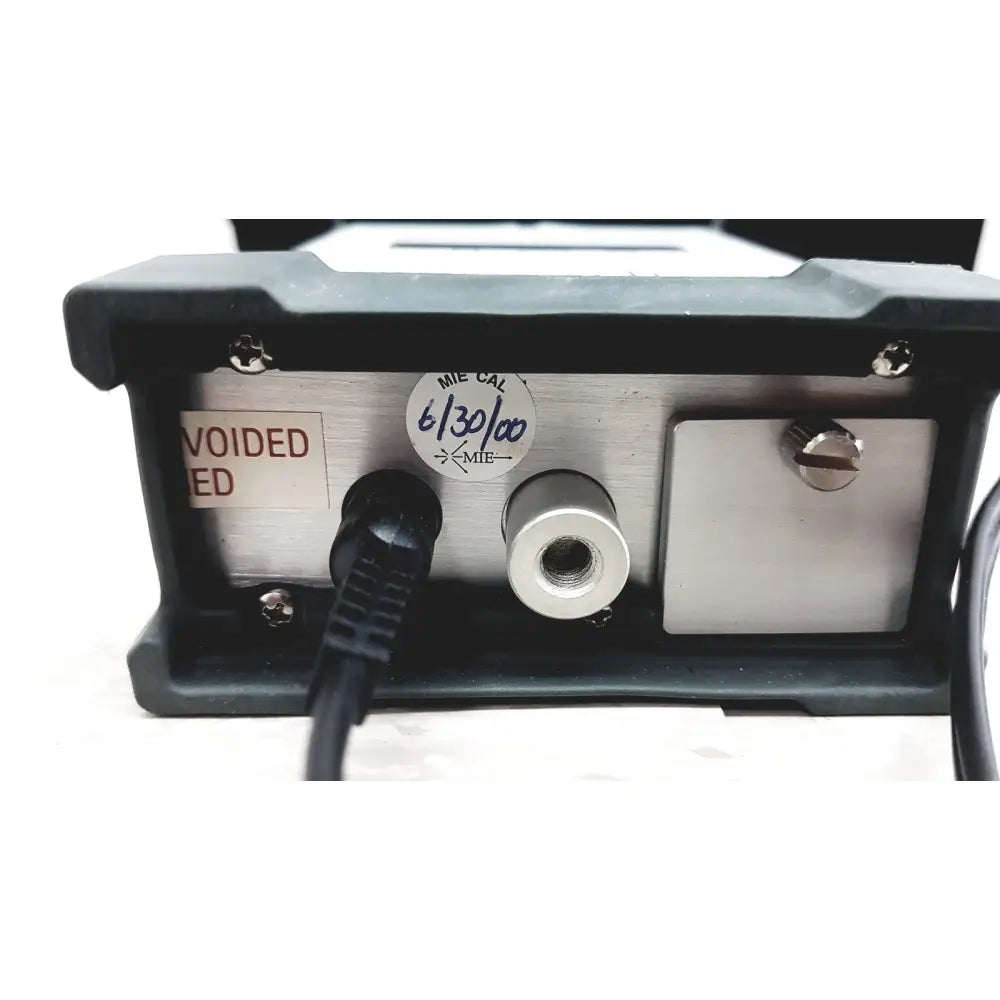 Back side of black and silver mie personal dataram real-time aerosol monitor with calibration sticker on its metallic panel