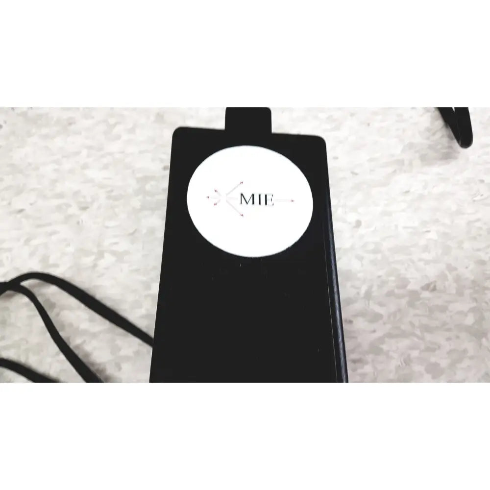 Black rectangular wireless charging pad with white circular mie logo for the mie personal dataram PDR-1000AN monitor
