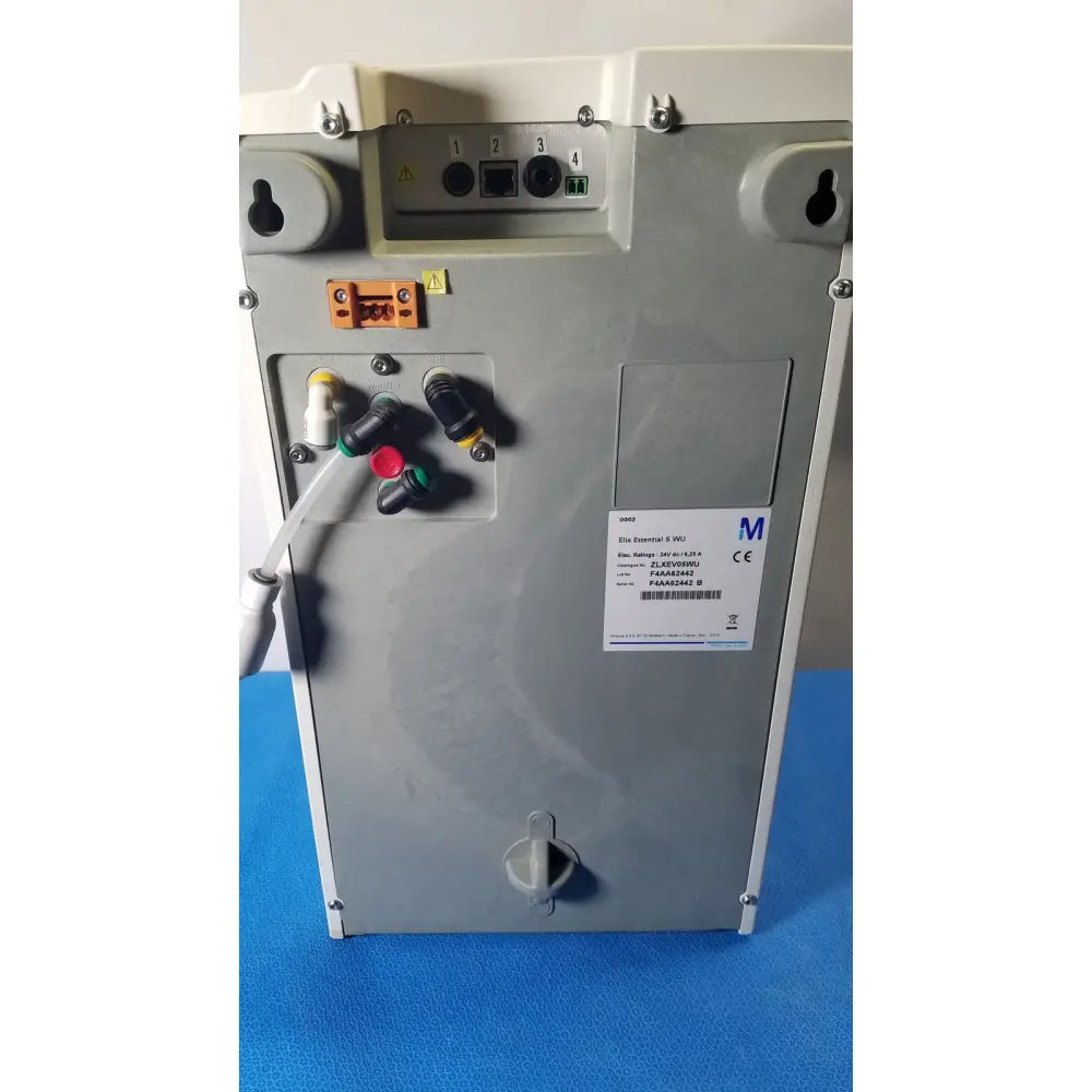 Gray metallic industrial control panel with labeled ports and warning symbols on the back of millipore elix essential system
