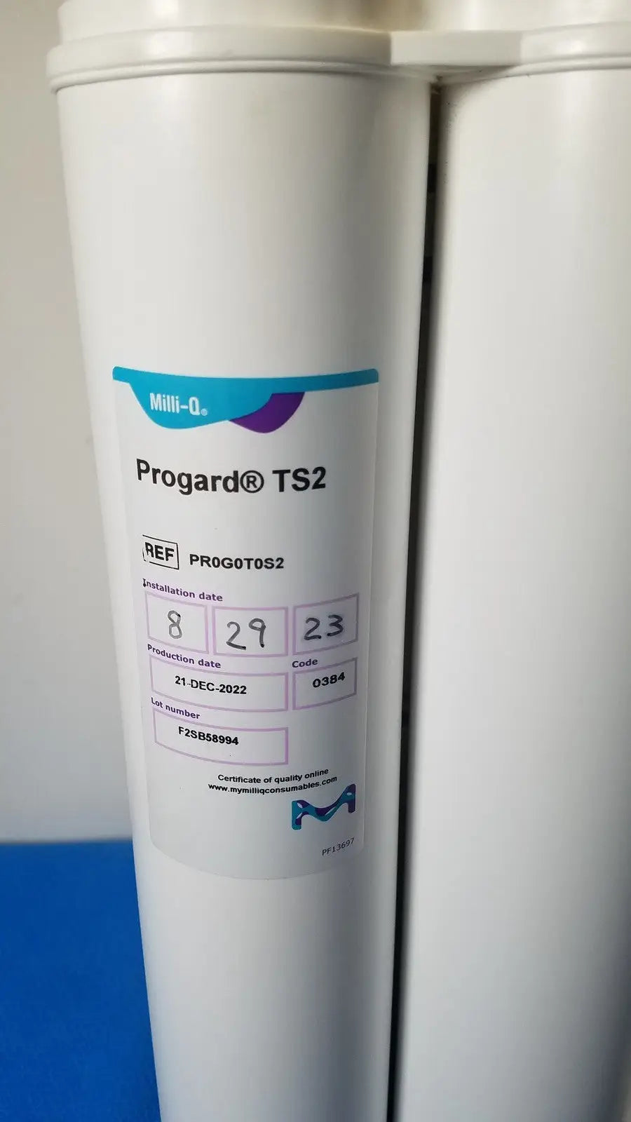 White cylindrical water filter with blue and purple milli-q label for millipore elix essential 5 uv water purification system