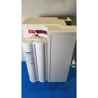 Cream-colored millipore elix essential 5 uv water purification system with two progradis t92 filters and red uv sticker on top panel