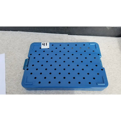 Blue plastic sterilization instrument tray by Mitek Products with grid of circular holes and reinforced corners