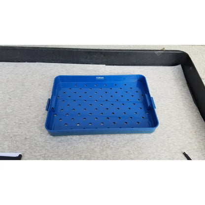 Blue plastic sterilization instrument tray with perforated surface and side handles by Mitek Products