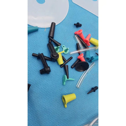 A collection of colorful plastic and clear tubing connectors on a blue surface from the mityvac mv8500 elite automotive kit