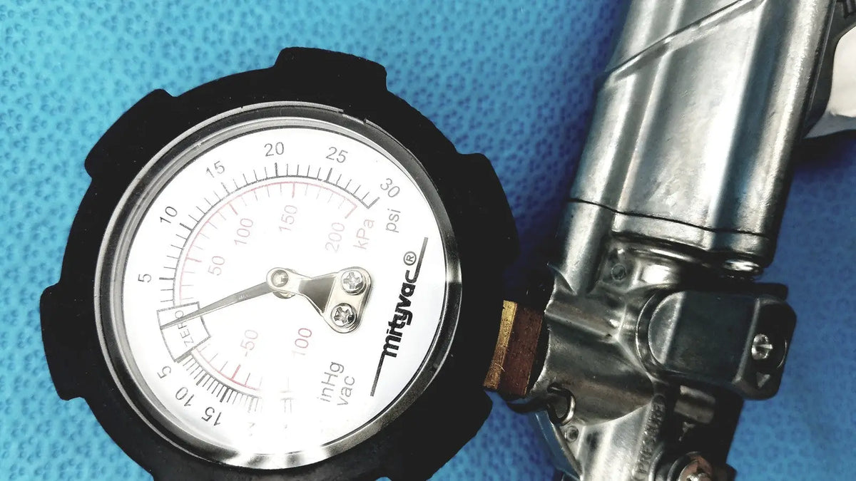 Black-rimmed pressure gauge with white face and silver needle in the mityvac mv8500 elite automotive kit