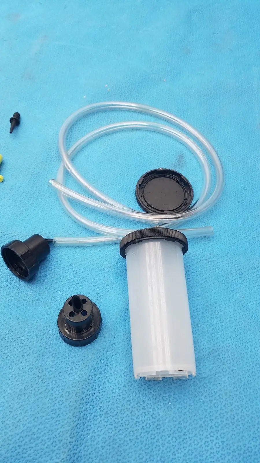 Clear plastic syringe-style fluid reservoir with black threaded cap and tube in mityvac mv8500 elite automotive kit