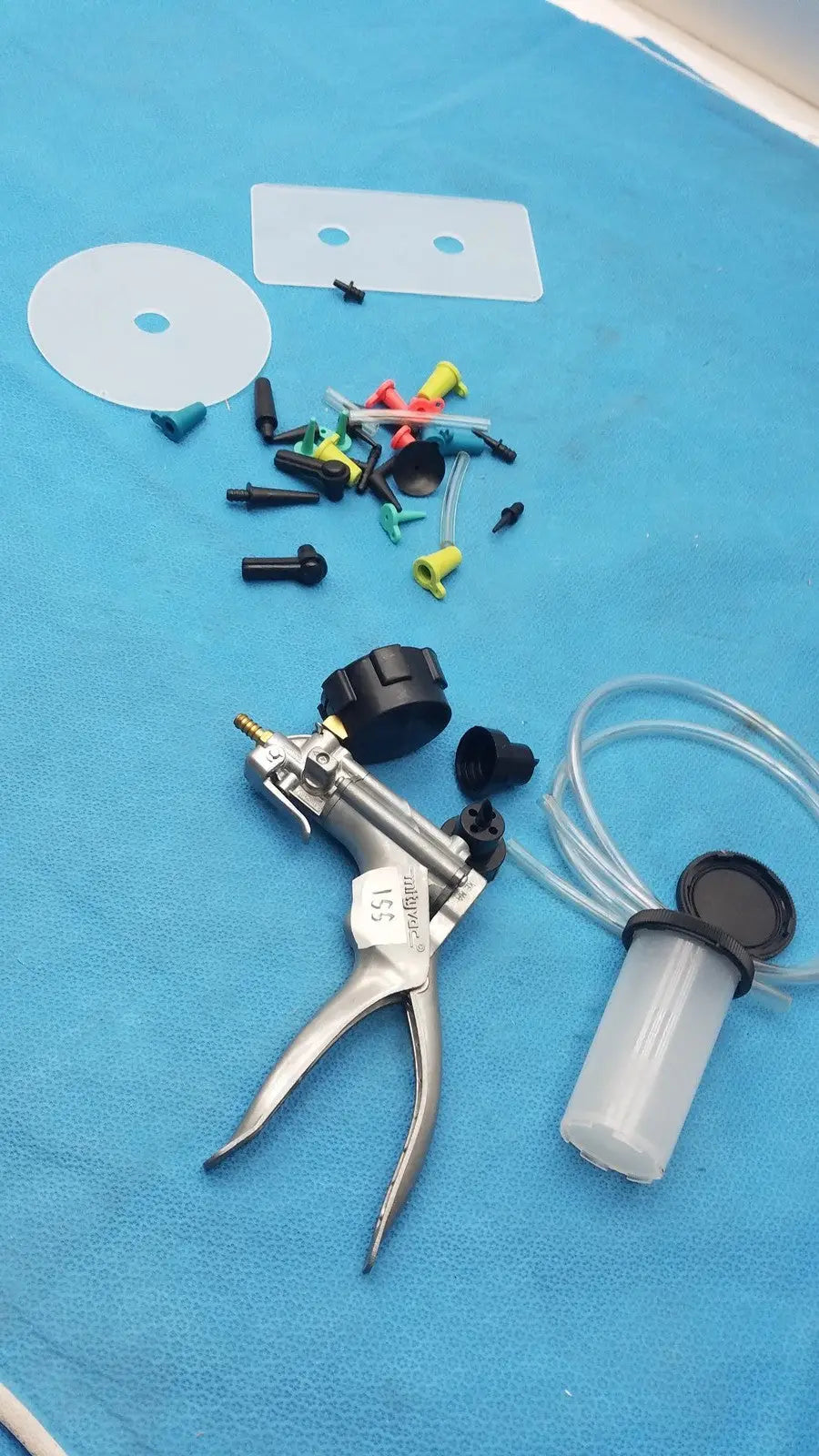 Silver-handled medical syringe pump with black caps clear tubing and colored connectors in mityvac mv8500 elite automotive kit