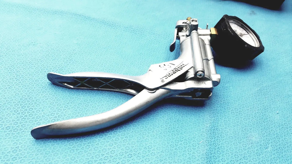 Silver metal punch tool with black rubberized grips and pressure gauge in mityvac mv8500 elite automotive kit