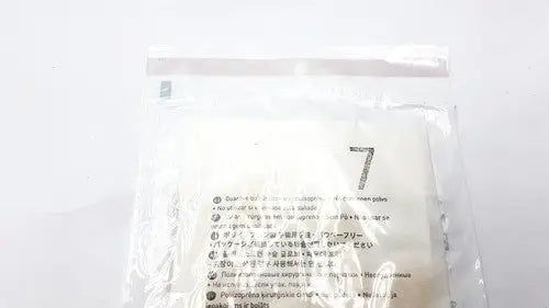 A clear plastic bag with white soft filter papers and multilingual instructions for molnlycke biogel pl surgical gloves size 7
