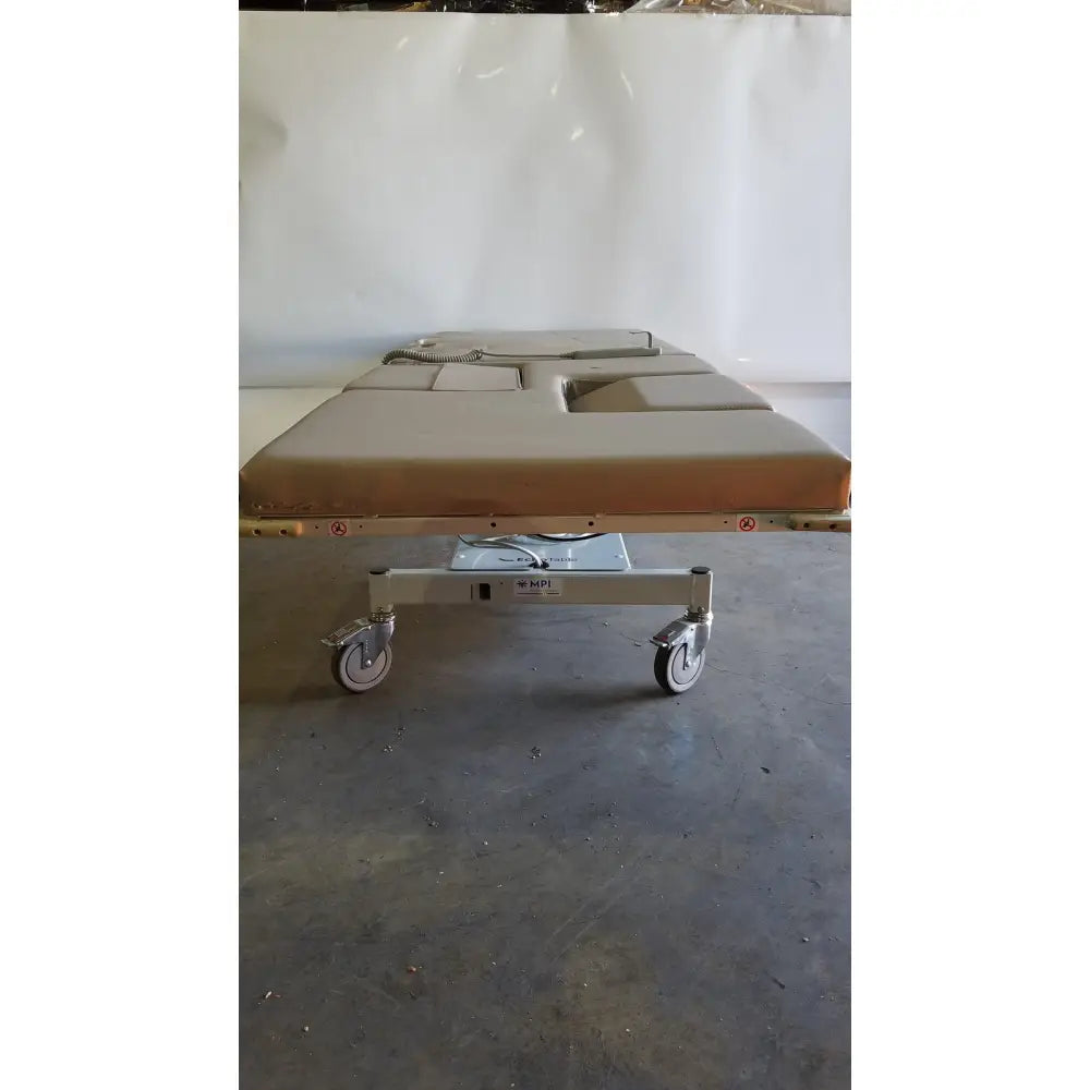 Beige upholstered mpi imaging table model 251 echo table with metal frame and casters and th2 handset