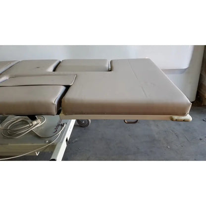 Beige padded mpi imaging table model 251 echo table with segmented cushioning and metal frame with th2 handset