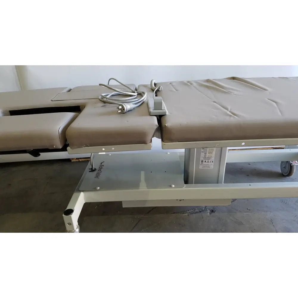 Beige padded mpi imaging table model 251 echo table with segmented sections and silver metal frame with TH2 handset