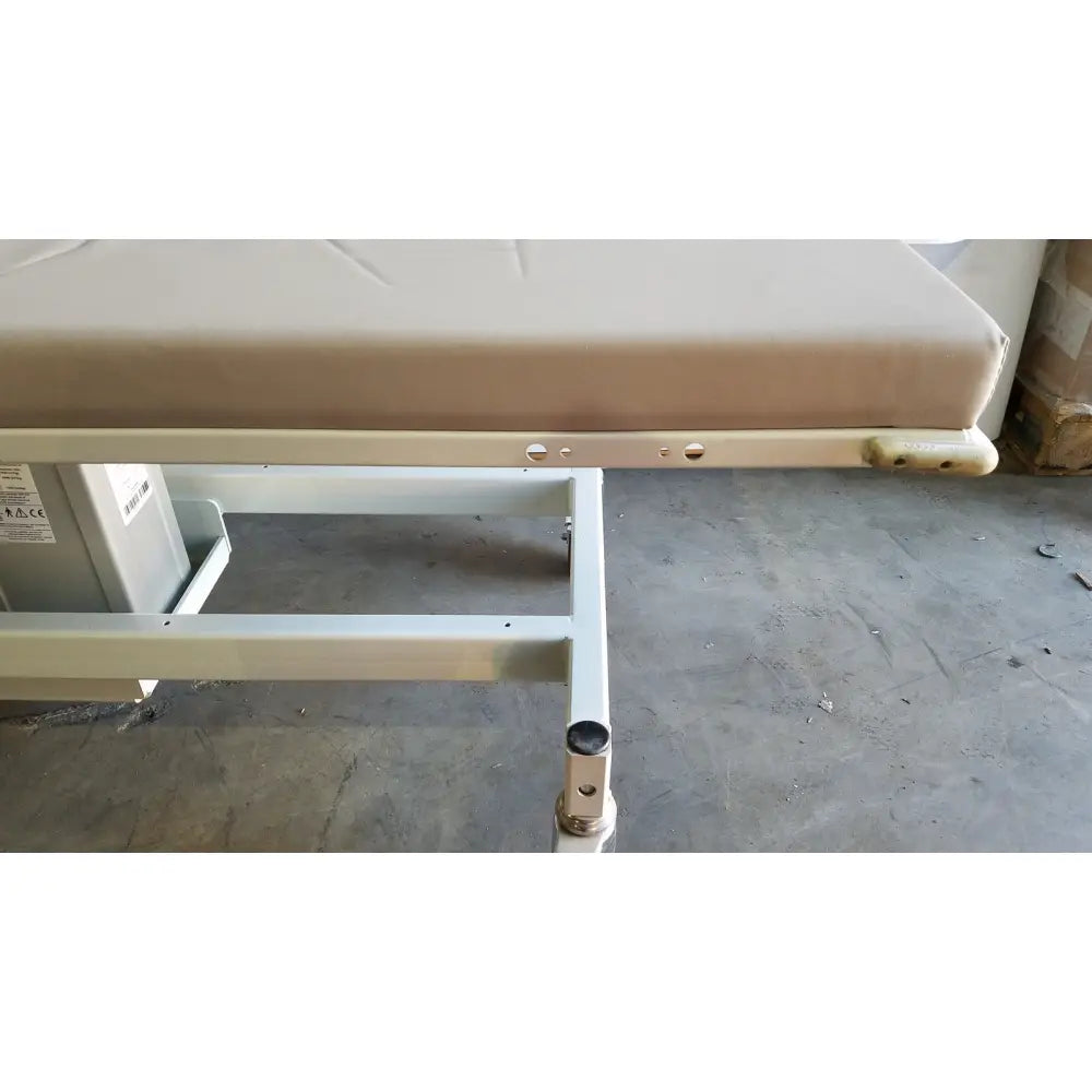Beige padded mpi imaging table model 251 echo table with metal frame and adjustable legs for medical use