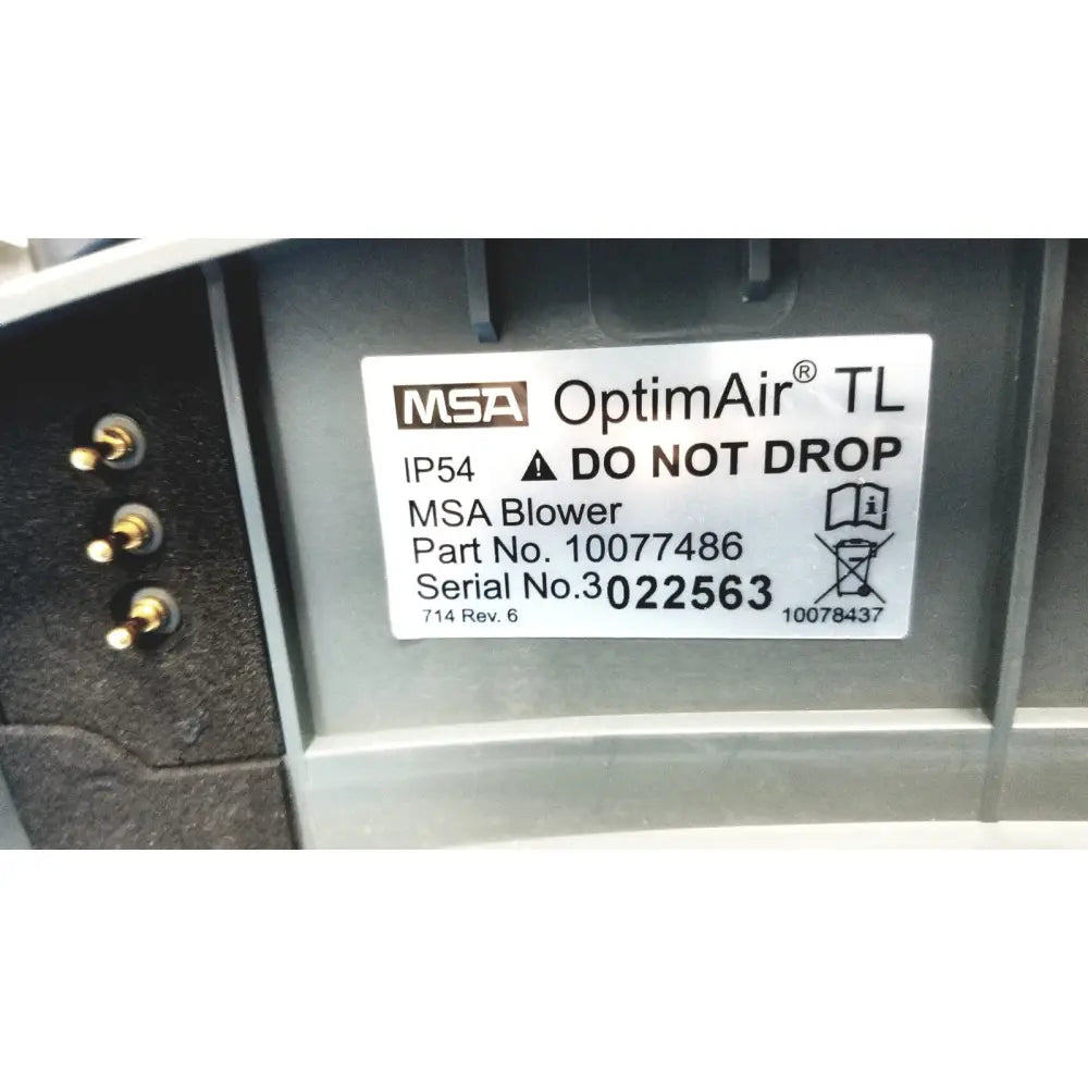 White label on the back side of msa optimair tl papr blower unit showing part and serial numbers ip54 rating and do not drop warning