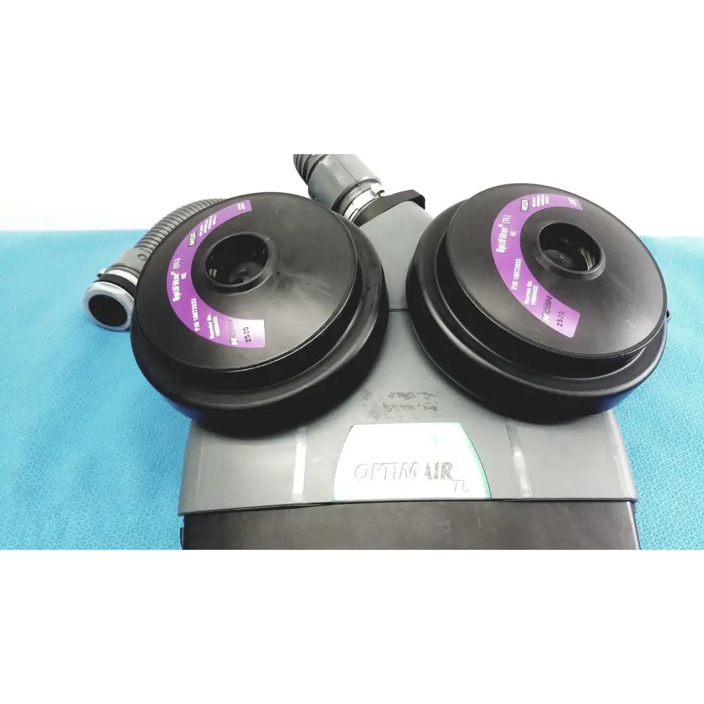 Black circular air filtration cartridges with purple labels on gray msa optimair tl papr blower unit with battery