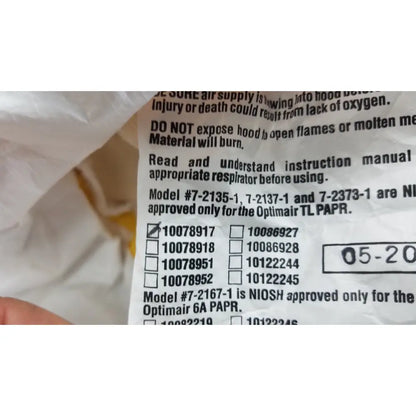 White paper label with black printed respirator model numbers and safety instructions on back of msa yellow safety respirator s-cap hood 10078917