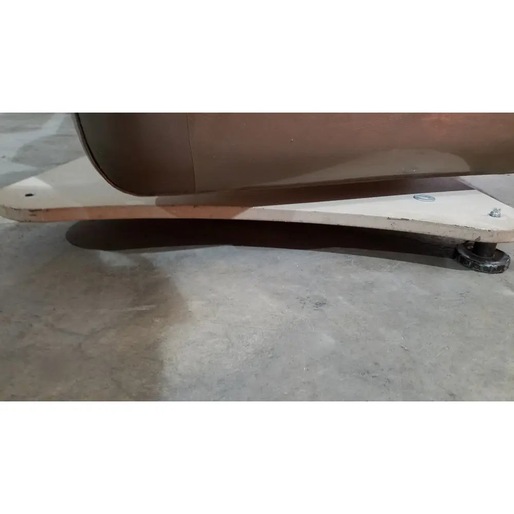 Brown leather sofa base with white metal support frame and black caster wheels of mti programmable podiatry chair